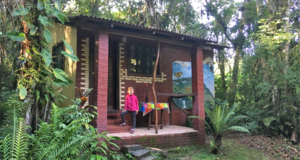 Suzie debout devant la cabane au milieu de la jungle brésilienne