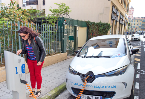 Femme rechargeant sa voiture électrique © 123RF