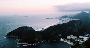 Paysage au bord de la mer avec un un mont, vue sur la ville de Rio, sous un ciel orange et gris